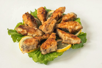 fried fish on a white plate with lettuce and lemon