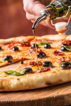 Chef and pizza. Chef pouring olive oil on  pizza in hotel or restaurant