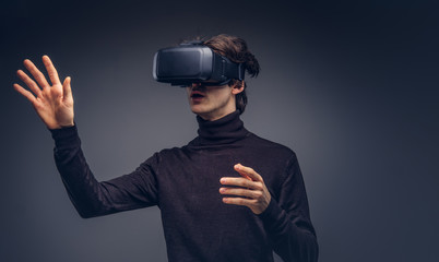 Portrait of a man wearing virtual reality device isolated on a d