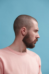 Naklejka premium Suspiciont. Doubtful pensive man with thoughtful expression making choice against blue background