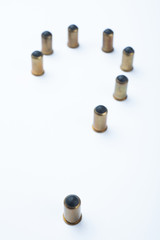 A question mark is laid out of rubber bullets and cartridges.