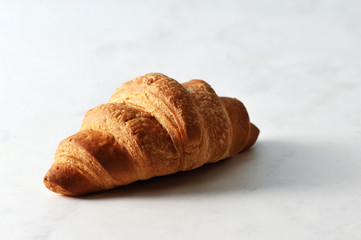 fresh croissant on white marble