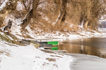 Abandoned boats on the shore of the lake in the winter