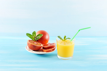 orange juice in glass with mint and a straw