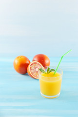 orange juice in glass with mint and a straw