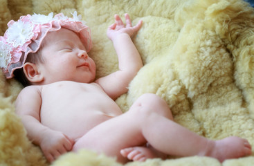 Newborn baby girl smiling in a dream ,Newborn baby girl is sleeping on fur blanket