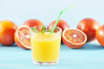 orange juice in glass with mint and a straw