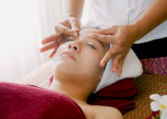 Closeup of young woman getting spa face massage at beauty salon.