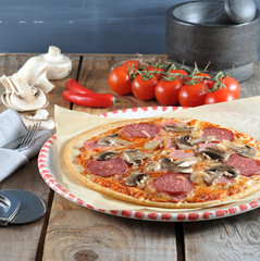 Homemade cheese pizza with salami and champignons