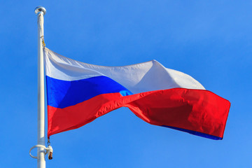 Naklejka na ściany i meble Flag of Russian Federation on the blue sky background. Waving flag of Russia
