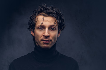 Portrait of a charismatic sensual male in black sweater with wet