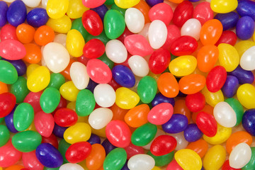 Fototapeta na wymiar Many brightly colored jelly beans in a rainbow of colors. Popular candy for Easter.