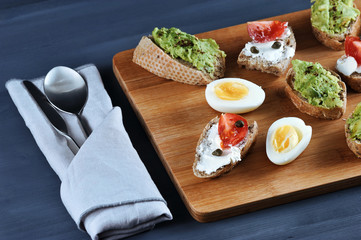 canape sandwiches on a wooden Board
