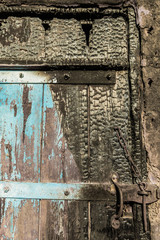 Fragment of the burnt door after the fire. Chapped texture.