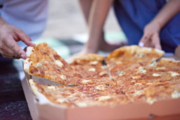 Romantic dinner in the nature by candlelight with pizza. Two lovers eat pizza. Romantic date for two.