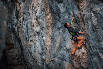 Men climbs a rock, 7c pitch with a rope, lead. Chitdibi, Turkey