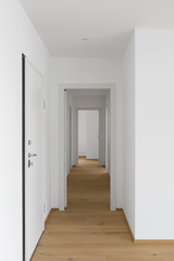 Empty white corridor with open doors