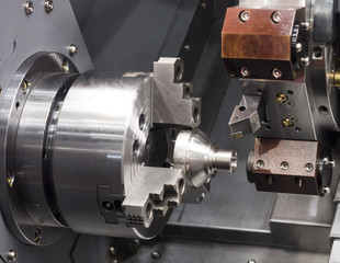 Obraz na płótnie Canvas machining automotive part by cnc turning machine