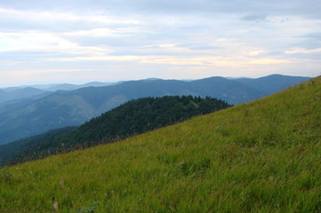 The landscape of multi-colored cloudy sky at sunset above the mountain ridges of the Ukrainian Carpathians.