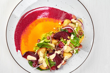 Healthy diet: colorful beetroot salad with potatoes and shredded leaves. Close up