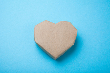 Paper heart made from recycled paper on a blue background.