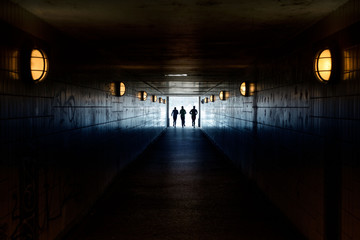 Three People Running Away Through Tunnel