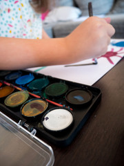 Small girl painting with watercolors