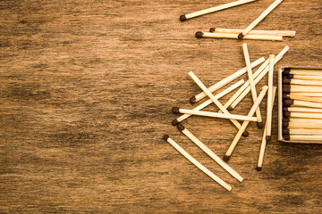 Matches in box, dark background. Close-up shot. Matches in open match-box on carton underlay