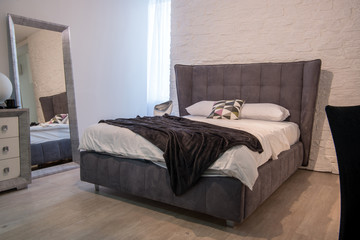 Interior of modern bedroom with bed and mirror