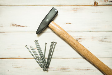 Repair carpenter tools: hummer and nails on white old wooden background, top view, copy space