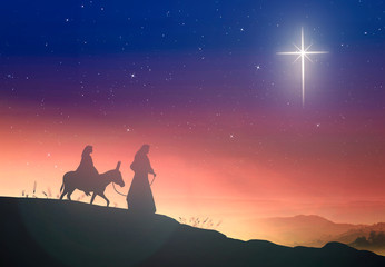 Christmas religious nativity concept: Silhouette pregnant Mary and Joseph with a donkey on star of...