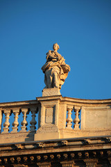 Fototapeta na wymiar statue sopra ringhiera di un terrazzo nel centro città