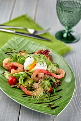 Salad from shrimp with lettuce, arugula, eggs, tomatoes, olive oil and balsamic vinegar.