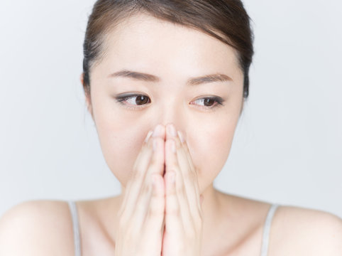 口元を隠す女性