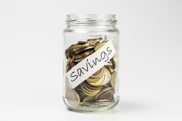 Glass jar full of coins on white background