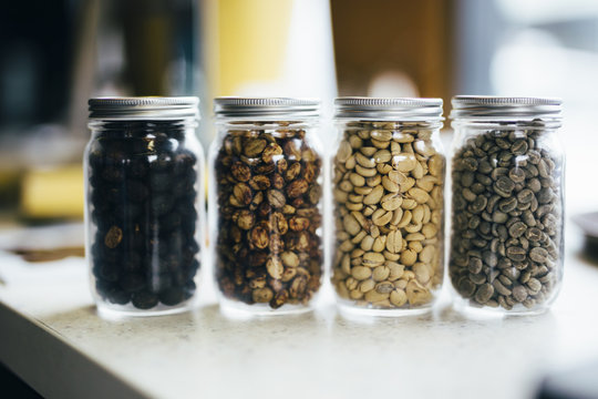 Four types of coffee beans in glass jars