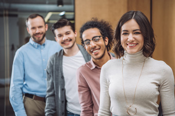 Obraz premium group of successful businesspeople standing in row and looking at camera at office
