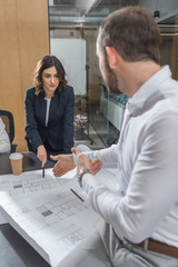 team of successful architects working with building plans together at office