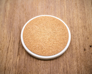 Beverage coaster mug made from ceramic material on retro background.