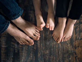 Bare feet of family members-mother, father and child.