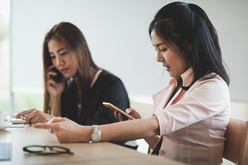 Young woman worker talking with smartphone in office