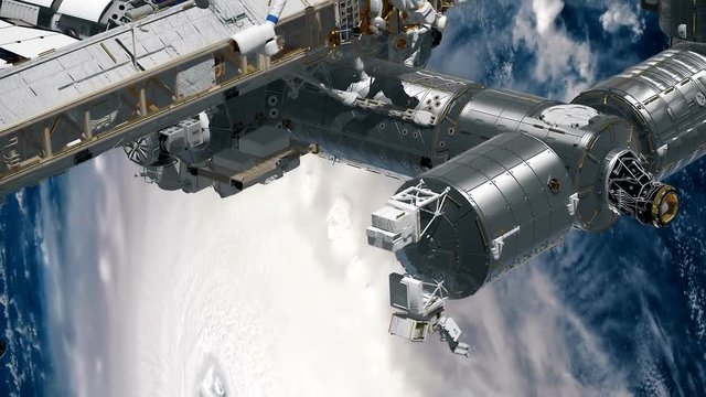 CG Animation of International Space Station ISS revolving over earths atmosphere. Astronaut Spacewalk. Elements of this image furnished by NASA.