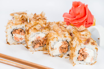 Traditional Japanese cuisine. Tasty sushi rolls with rice, cream cheese, salmon and tuna on light background