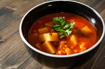 Bean and vegetables soup in ceramic bowl on wooden table