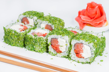Japanese cuisine. Appetizing Philadelphia maki with rice, cream cheese, salmon, pepper and dill on light background