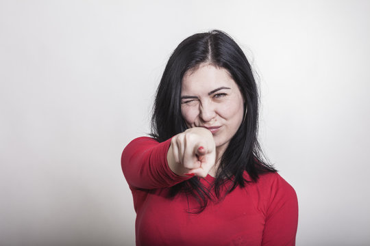 Schwarzhaarige Frau zeigt mit dem Zeigefinger auf Dich