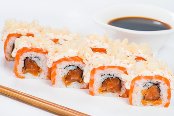 Appetizing maki sushi rolls with rice, salmon, tuna and sauce on light background