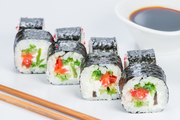 Tasty fresh Sake Avocado Maki sushi with rice, avocado, tobiko and salmon on light background