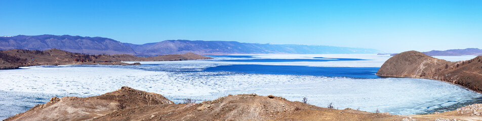 Baikal Lake in spring day. Top view of the Kurkut Bay at the beginning of the ice drift. White ice on blue water. Panorama