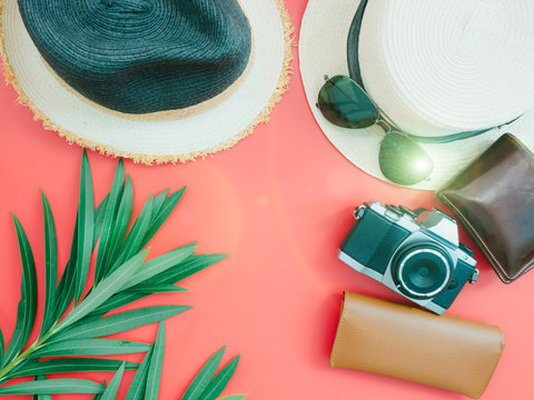 flat lay for summer cloth and accessories concept with red background and two beach hat